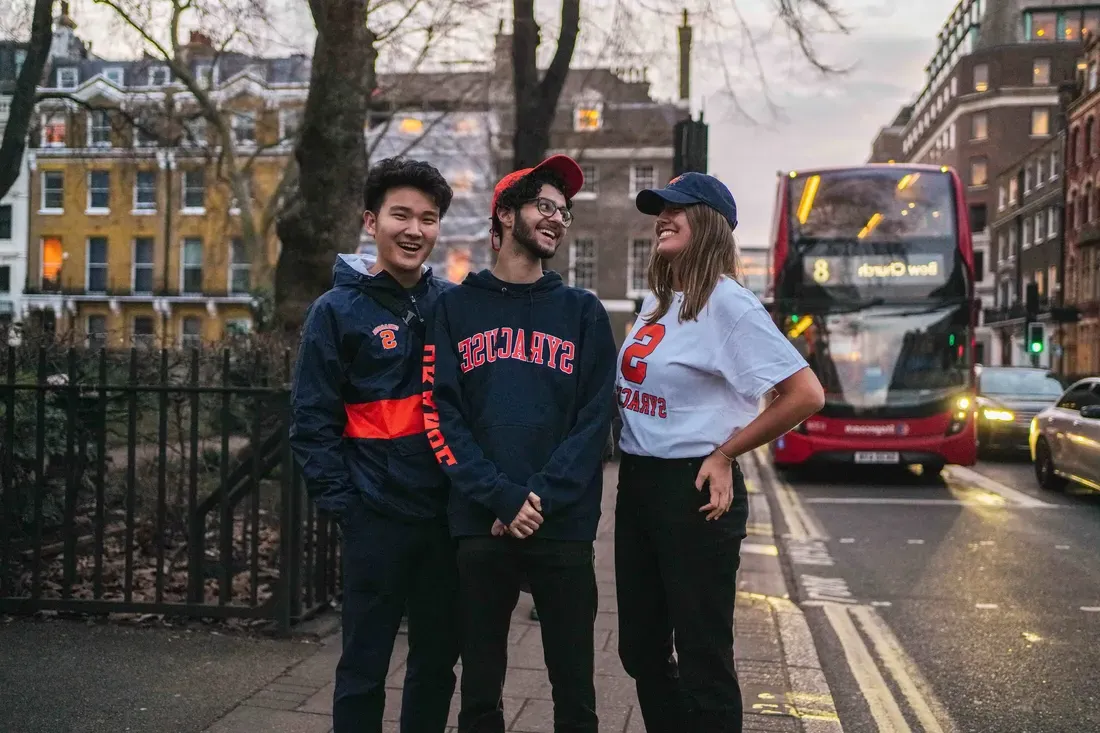 三个学生在伦敦的大街上笑着.